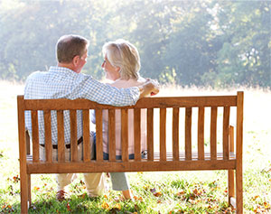 middle age couple sitting together on a bench